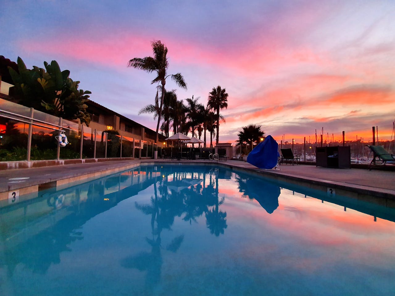 pexels photo 2983472 Poolside view with palm trees during a vibrant sunset in San Diego.